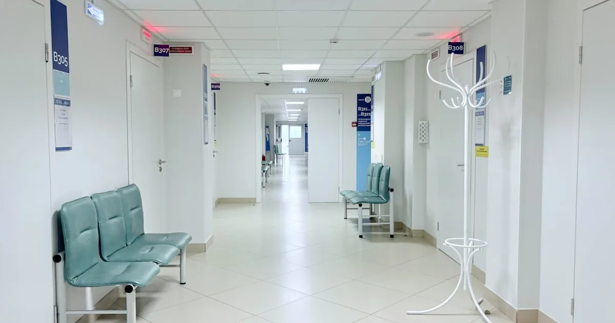 Leerer Klinikflur mit zugangsgeschützten Türen.
