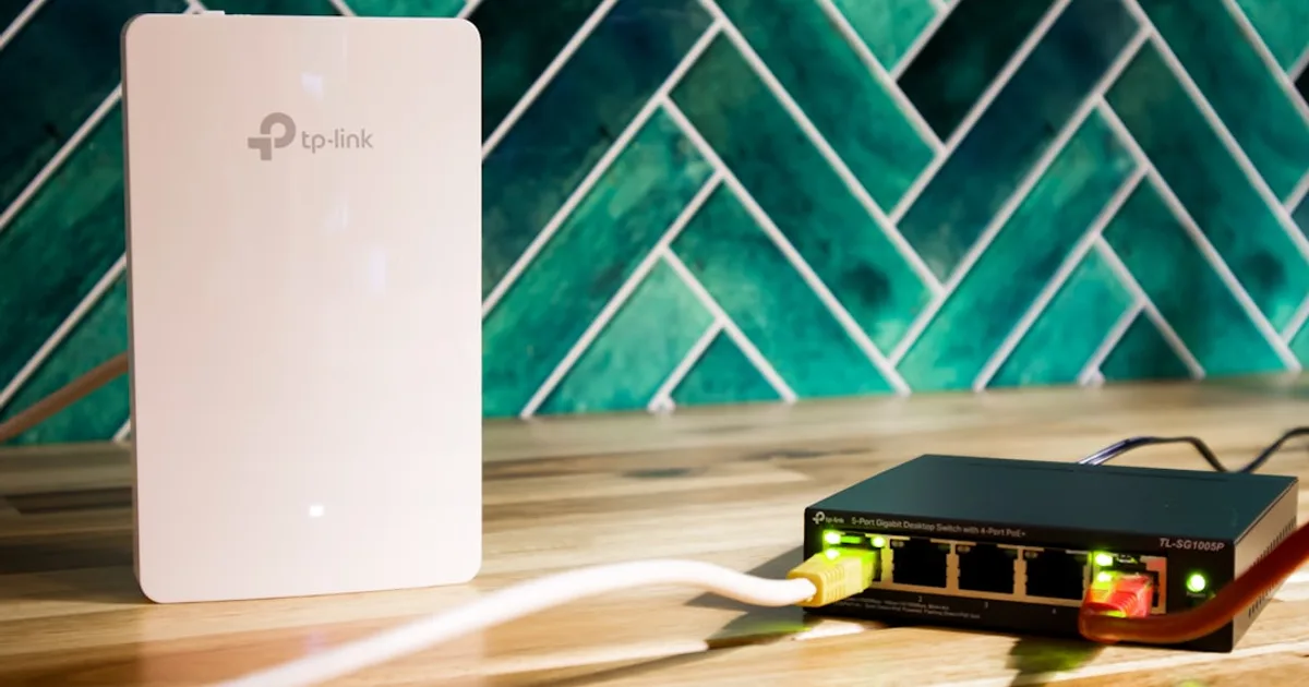 Ein WLAN-Router und ein Netzwerk-Switch stehen nebeneinander auf einem Schreibtisch.