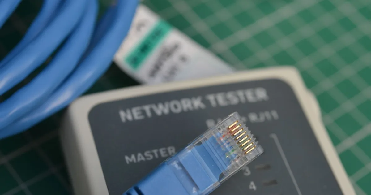 Nahaufnahme eines Netzwerk-Testers auf Cat6a-Verkabelung.